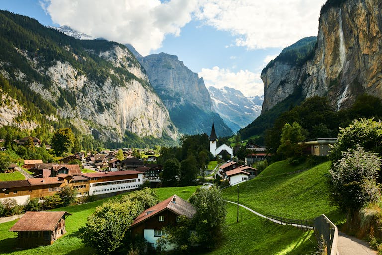 Scenic view of the Lauterbrunnen Valley with Swiss chalets and dramatic mountain cliffs in summer