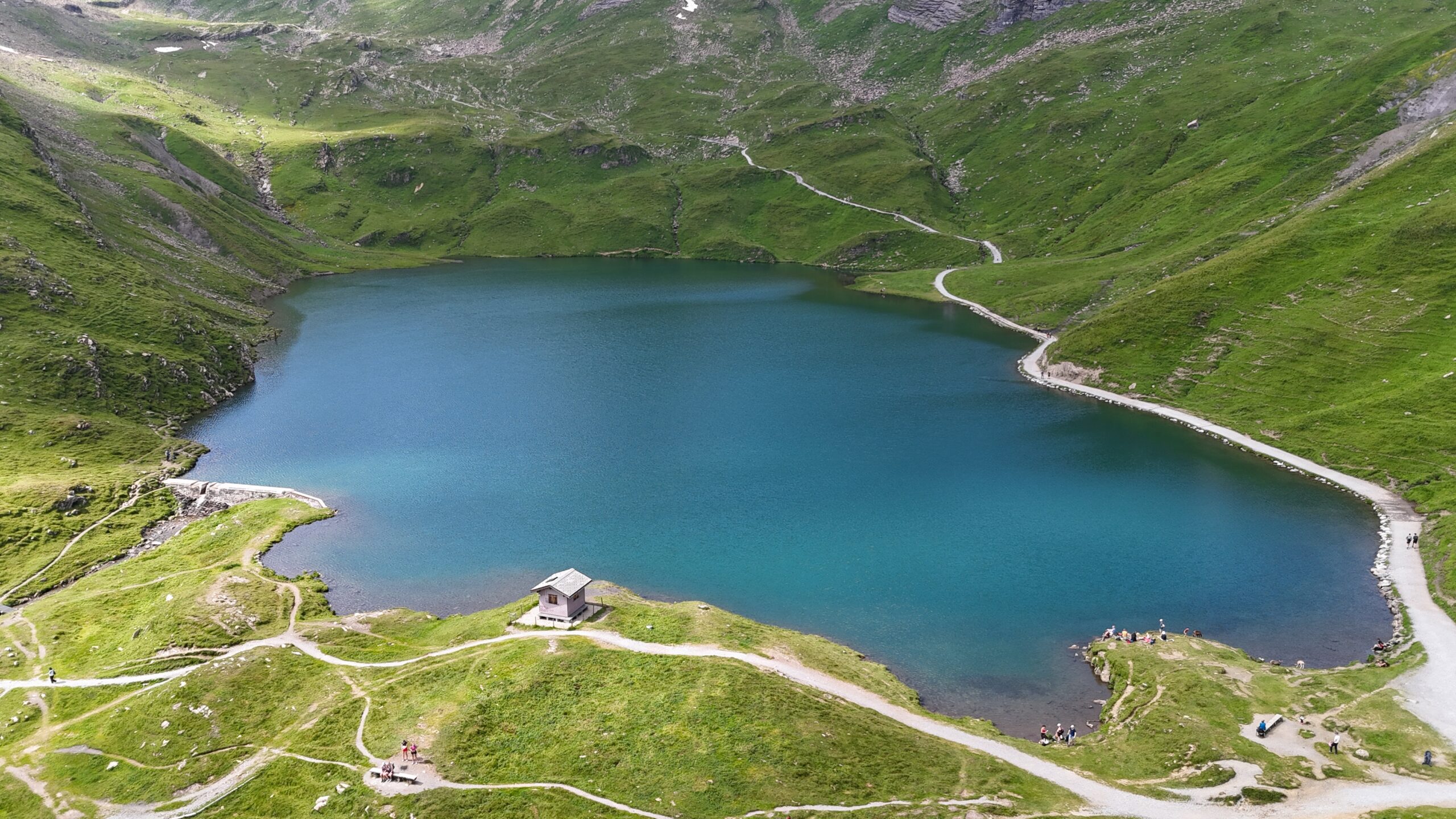 Aerial drone view of turquoise Bachalpsee and the trails winding around its shore
